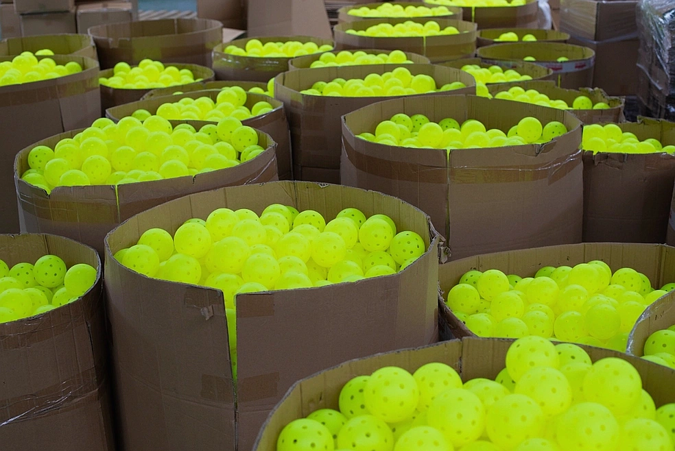 Quality control team inspecting bulk pickleball stock