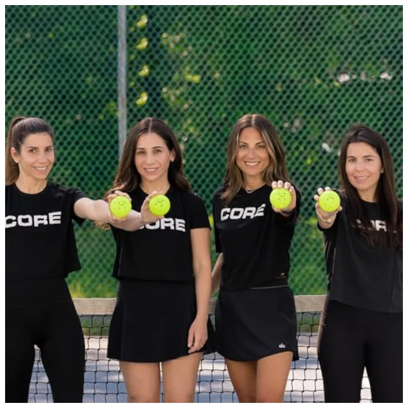 CORE balls in motion on sunlit outdoor court showing high contrast against concrete