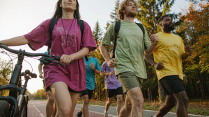 Group of cyclists, runners and hikers wearing matching custom quick-dry moisture-wicking team t-shirts on a sunny outdoor trail